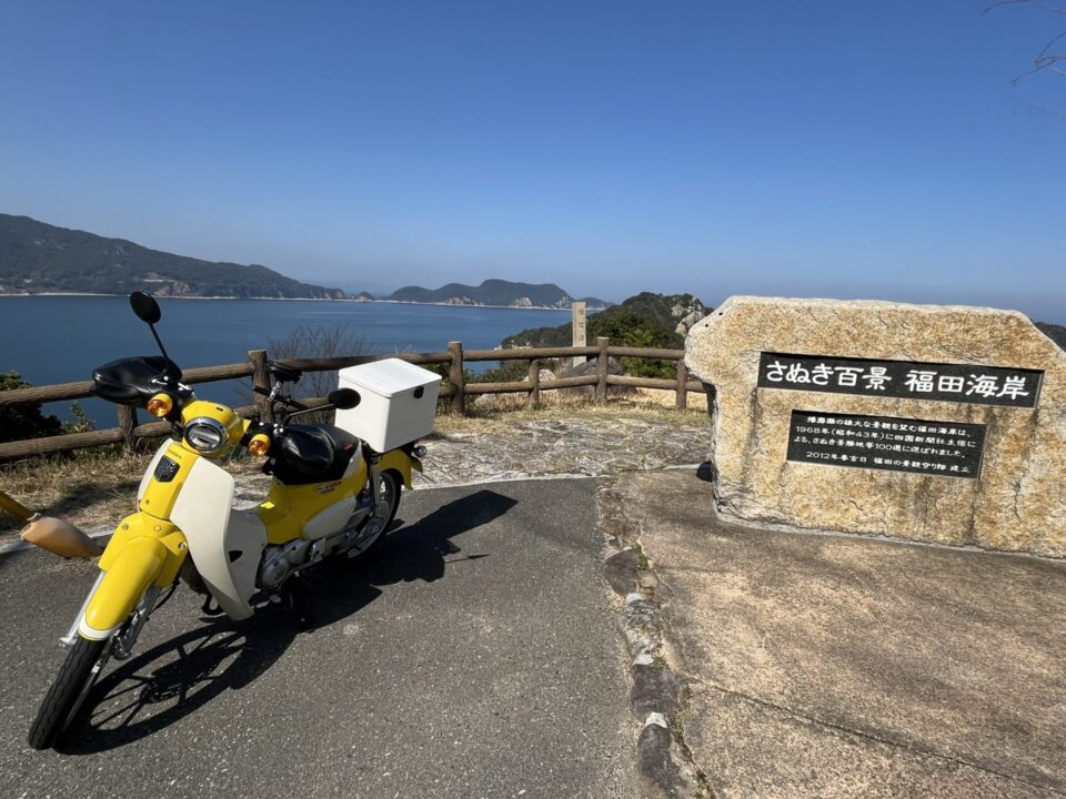 「さぬき百景 福田海岸」をバックにスーパーカブ